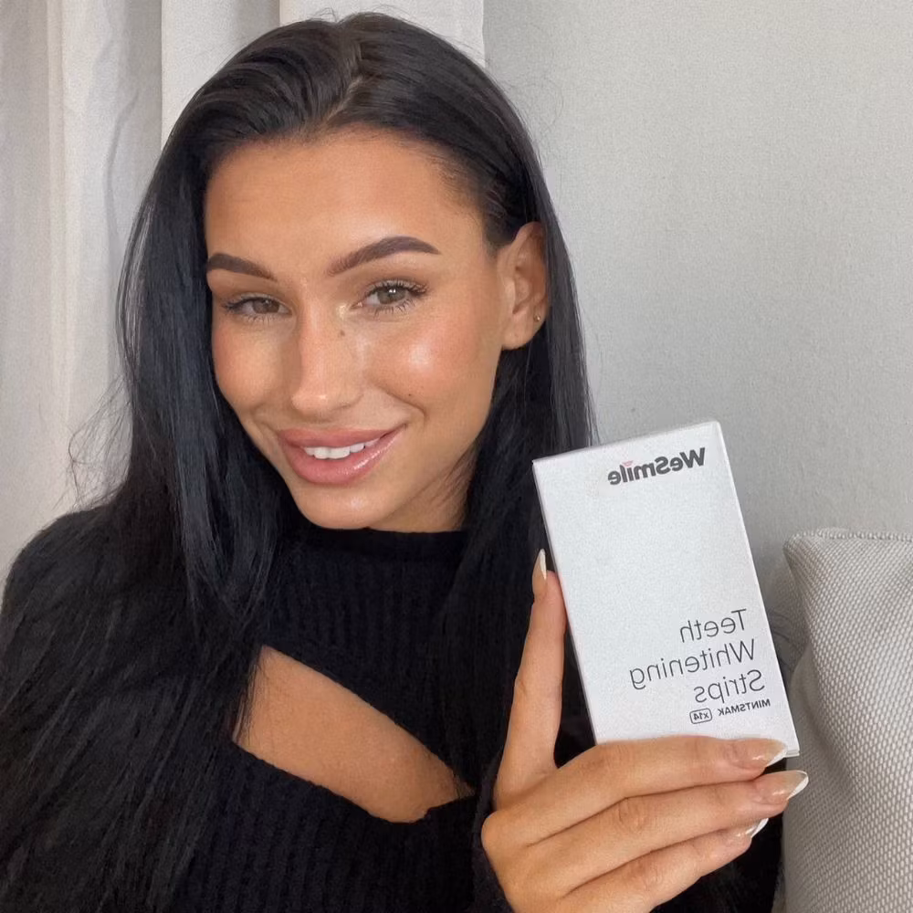 En kvinna som håller asken med strips